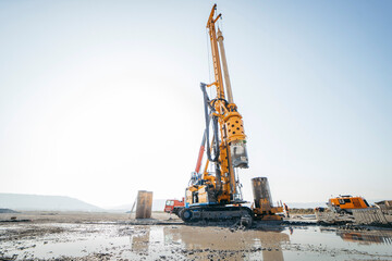 Drilling rig on a construction site. Drilled piles for the bridge foundation.  - obrazy, fototapety, plakaty