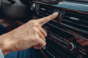 Fototapeta premium Male hand pushing button in his automobile