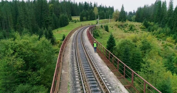 Aerial shot construction worker on railways. Engineer work on railway. Engineer walking and check track work on railways. People walk on railway. Engineer work on railway.