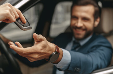 Image of man getting the keys to the automobile from the seller - obrazy, fototapety, plakaty