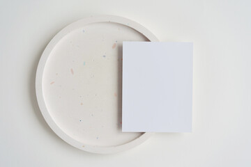 5x7 vertical card mock up on terrazzo plate on white background. Minimalist mock up for designers