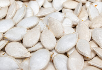 White pumpkin seeds as background.