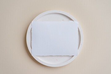 Raw edge handmade paper. Name card mock up on terrazzo plate on beige background. Branding concept. Menu mock up