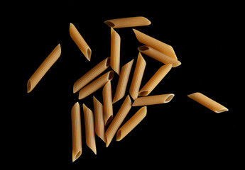 Dried pasta isolated on black background.
