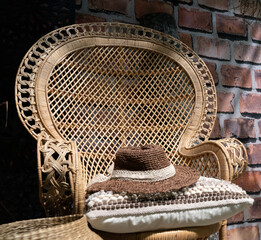 Cozy summer garden chair in rattan and in soft morning light on the terrace, inviting to relaxation. Shallow depth of field.