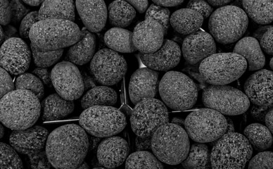 Black ceramic Pebbles used in a fireplace burning on gas or ethanol. Top down view.
