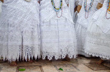 Detalhes de roupas brancas de mulheres em cerimônia no candomblé