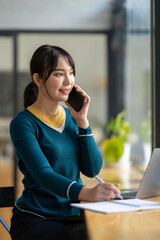 Asian business woman making a phone call and smiling indoor, During break from working in modern office. Mobile business technology concept
