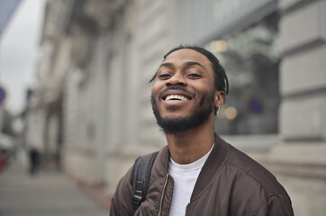 Fototapeta premium young smiling man with backpack in the street