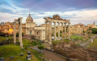 Fototapeta na wymiar View of the temple of Saturn in Roman forum, Italy. Ruins of Septimius Severus Arch and Saturn Temple. Rainbow over the Roman forum. Rome architecture and landmark.