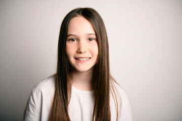 Obraz premium Young brunette pre teen girl on studio white