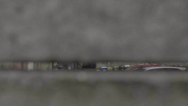 Hidden surveillance of a criminal through hole in the grey street wall. Stalking behavior is following the victim in person or monitoring them.