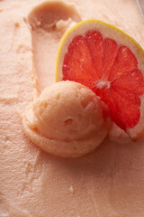Grapefruit sorbet texture and ball with a slice of fresh grapefruit.