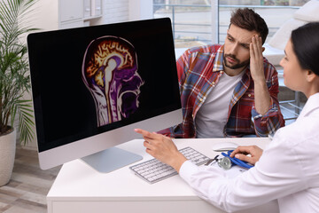 Neurologist showing brain scan to sad man in clinic