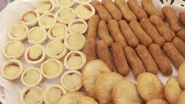Closed video of appetizers on a tray full of pastries and empanada to share, homemade food.