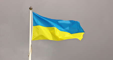 Ukraine national flag waving in wind against cloudy sky. Ukrainian Flag on flagpole flapping