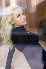 Beautiful blond woman with evening makeup, long waved hair, posing