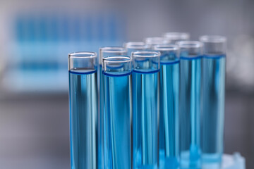 Test tubes with reagents on blurred background, closeup. Laboratory analysis