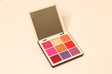 The concept of brand presentation and packaging with a mirror. A makeup palette floating on a white background. Professional multi-color eyeshadow palette with mirror. Cosmetic products. Close-up. - obrazy, fototapety, plakaty