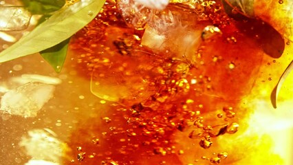 Super slow motion of pouring tea into water in twister shape. Fresh green leaves and ice cubes inside. Filmed on high speed cinema camera, 1000fps. - Powered by Adobe