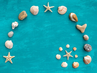 Flat lay spiral made of seashells, starfish and beach stones on aquamarine background
