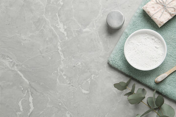 Flat lay composition with tooth powder and eucalyptus on light grey marble table, space for text