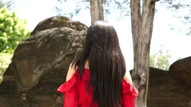 Mujer caminando en un parque y voltea.