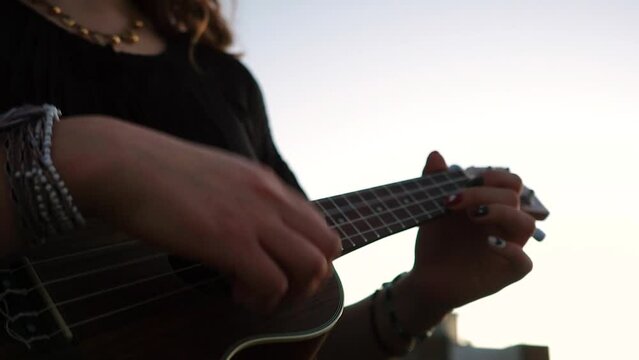 Plano cerrado de mujer tocando un ukulele. Concepto musical