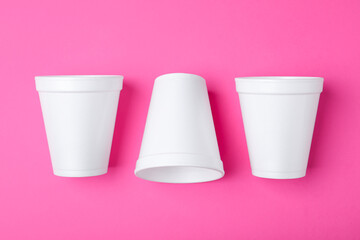 White styrofoam cups on pink background, flat lay