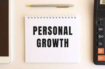 Notepad with text PERSONAL GROWTH on a white background. Business concept.