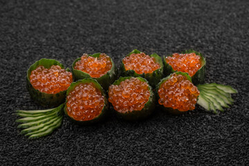 Sushi with red caviar, Asian cuisine. Photo of food on a dark background