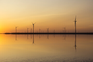 Plakat Wind Farm by the pink salt lake Lemuria in Ukraine. Silhouettes at sunset. Green energy concept