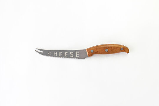 Kitchen chef knive for cheese laying on white background, flat lay, view from above, space for a text. Chef, restaurant or kitchen concept.