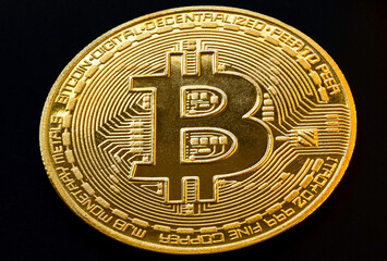 Closeup of a golden Bitcoin coin with white background. Cryptocurrency coin. Financial market. Macro. Selective focus