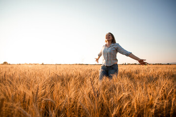 Woman with long hair in field at sunset