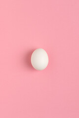 White egg on a pink background. Top view.