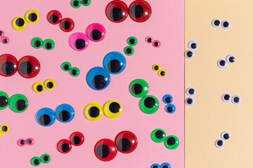 Multicolored plastic eyes. Diversity versus sameness concept. Googly eyes. - obrazy, fototapety, plakaty