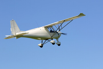 Ultralight airplane flying in a blue sky	