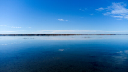 Lake with blue sky and trees on the horizon
