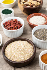 Assorted superfoods in over wooden background. Chia, quinoa, oat, linseed, honey, spirulina and others