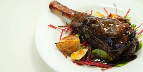 Delicious Lamb shank with red wine and rosemary gravy served on the mixed leaf salad