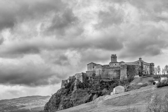 Black and white view of the Bardi castle, Parma, Italy, under a dramatic sky