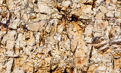 Grungy cragged bumpy pitted cavity stone facade, split layer gap.Ruined cracked shattered worn rough hiking canyon.Old ragged grunge steep marble cliff. Grand vintage crannied damaged impressive gorge