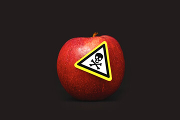 Concept for pesticide residues in agricultural food products dangerous to humans. A red apple with...