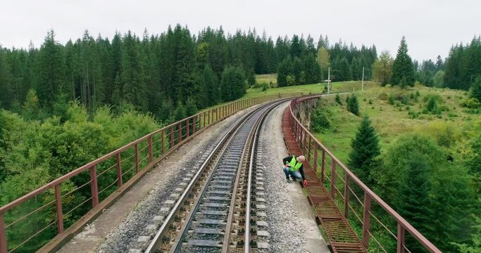 Aerial shot construction worker on railways. Engineer work on railway. Engineer on railway inspection. An Engineer walking on railways with inspection railroad under maintenance period.