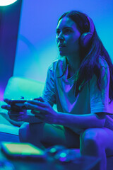 involved gamer girl playing video games on the console on the couch © Alberto