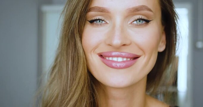 A beautiful blonde woman wrinkles her nose funny and shakes her head. She says no.