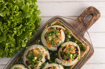 stuffed onion baked in the oven on a white plate.
