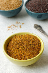 Powder spice blend from black and white mustard seeds and turmeric. Indian mustard powder seasoning in bowl.