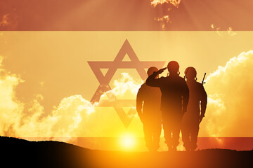 Silhouette of soliders saluting against the sunrise in the desert and Israel flag. Concept - armed...